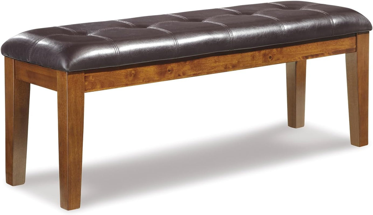 Signature Design by Ashley Ralene Tufted Upholstered Dining Room Bench, Medium Brown | Plush wipe-clean faux leather cushion, Frame of veneers, wood and engineered wood, Versatile 2-person entryway seating