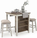Signature Design by Ashley Skempton 3-Piece Counter Height Dining Table Set | Two-tone acacia wood set, 3 built-in open shelves, 2 upholstered saddle stools, Space-saving tuck-away design, Dining room